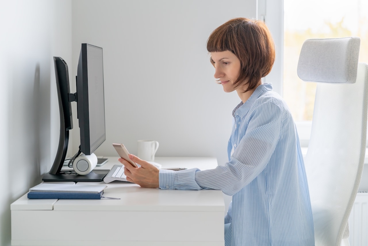 woman practicing password security while logging into her computer at her desk