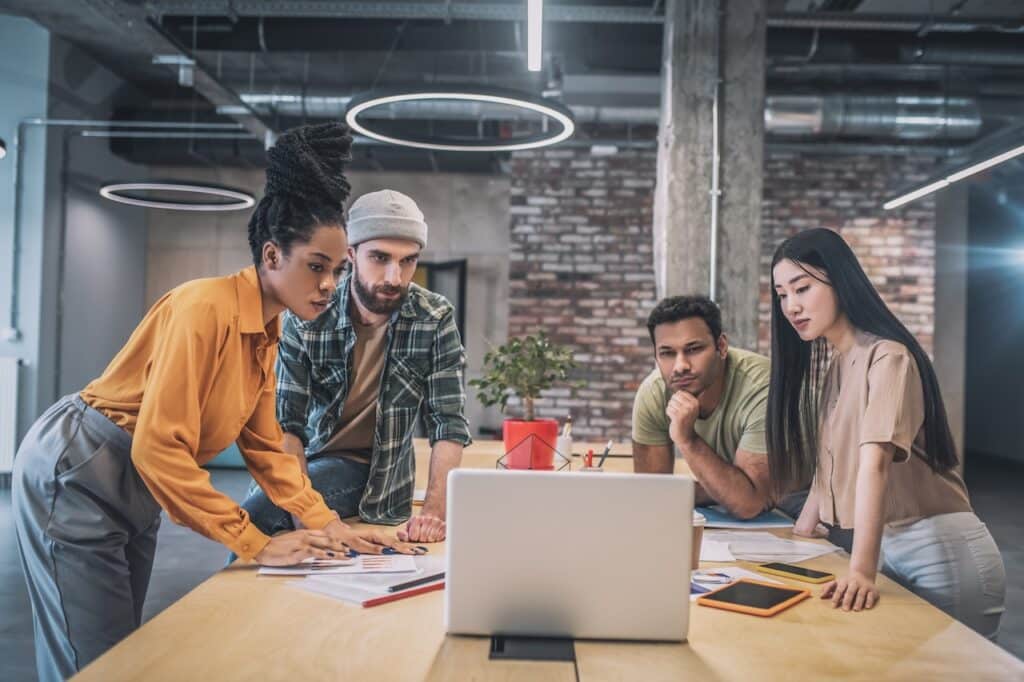 group of employees in meeting utilizing computer for research
